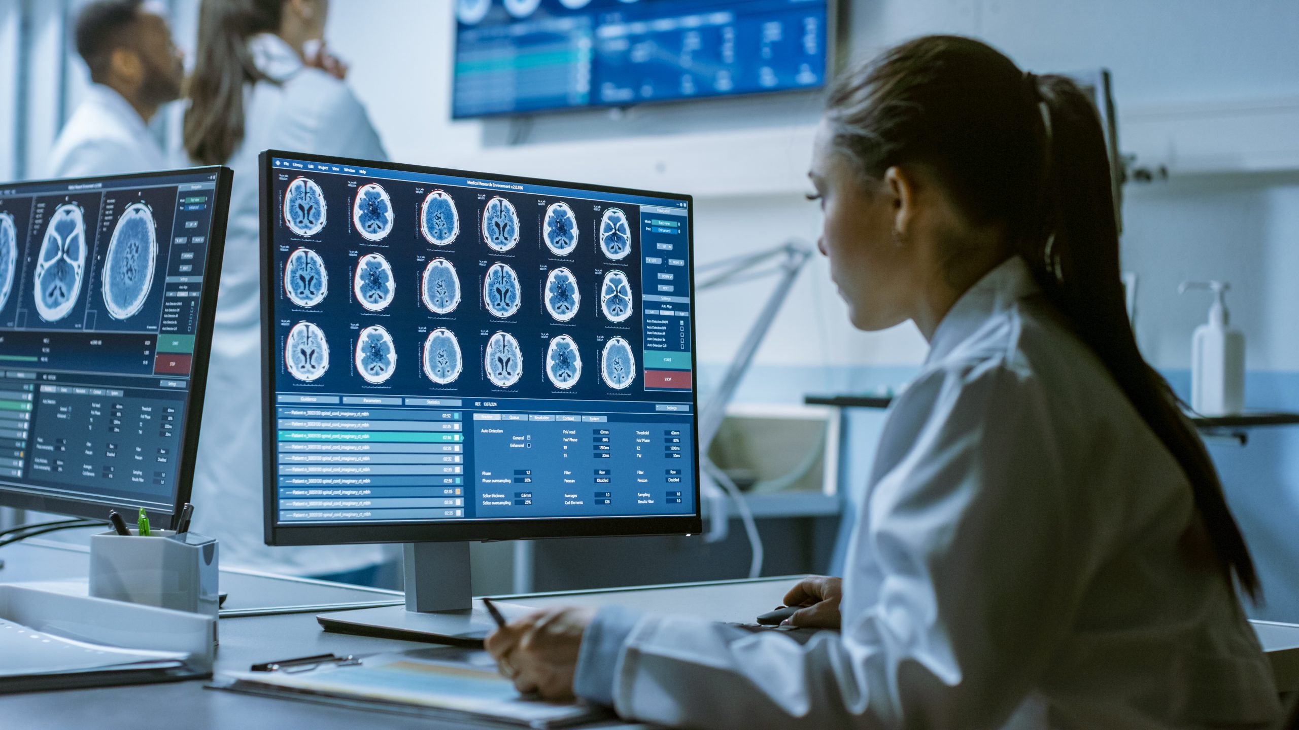 Female Medical Research Scientist Working with Brain Scans on Her Personal Computer, Writing Down Data in a Clipboard. Modern Laboratory Working on Neurophysiology, Science, Neuropharmacology.; Shutterstock ID 1197120043; Purchase Order: comps; Job: ; Client/Licensee: ; Other: